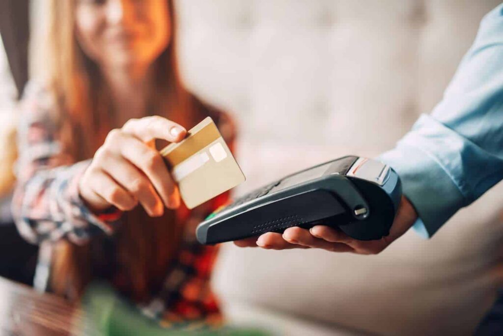 young-woman-paying-with-credit-card-to-handheld-terminal